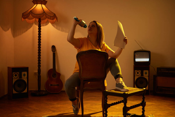 Mulher tocando música e cantando em um microfone sem fio em uma sala vintage retro. - Foto, Imagem