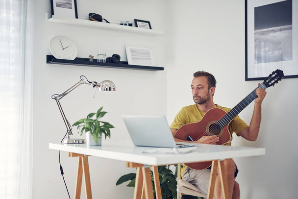 Man playing acoustic guitar at home. - Φωτογραφία, εικόνα