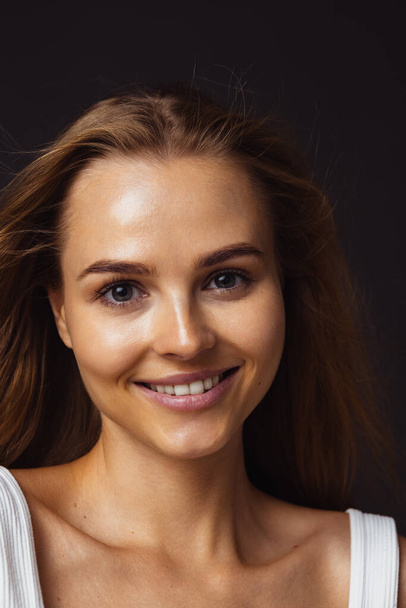 Close-up portrait of young beautiful caucasian woman isolated over dark brown studio background - Photo, image