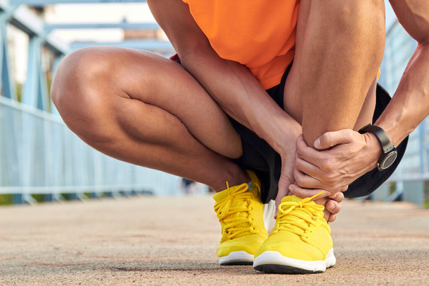 Sportovec se zraněním nohy při joggingu a cvičení v městském prostředí. - Fotografie, Obrázek