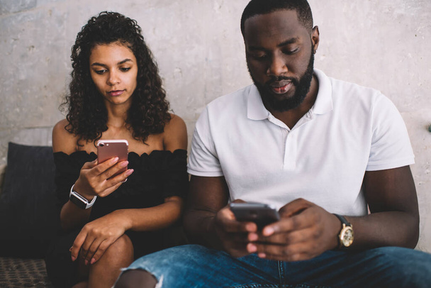 African American hipster guys ignoring live communication prefer smartphone networking and messaging on leisure, youthful male and female checking received emails have pda addiction lifestyle - Foto, afbeelding