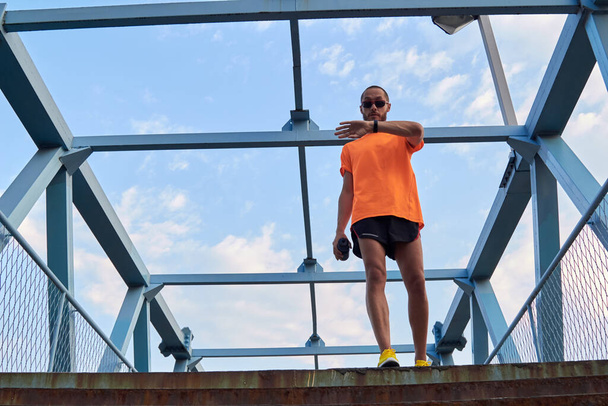 Sporcu şehir içinde açık havada antrenman yapıyor ve saate bakıyor.. - Fotoğraf, Görsel