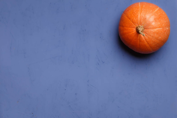 Fresh orange pumpkin on purple background, top view with copy space - Фото, зображення
