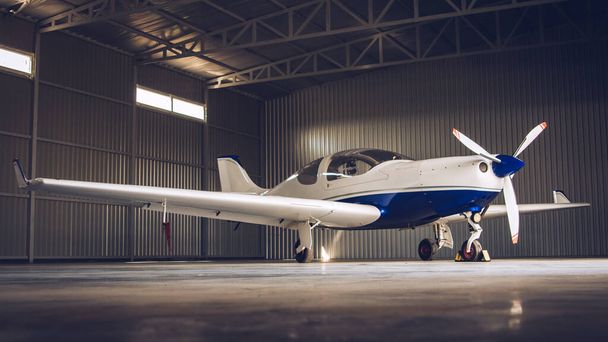 Small white private jet parked in the hangar - Photo, image