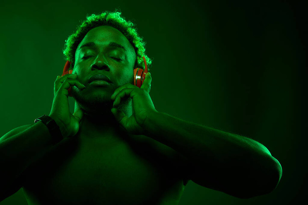 Black man enjoys music in red headphones - Foto, immagini