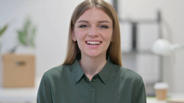 Mujer joven sonriendo a la cámara  - Foto, imagen