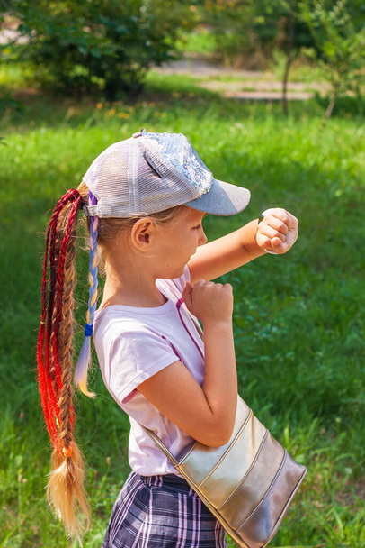 Uczeń dziecięcy korzystający ze smartwatch outdoor parku. Dzieciak gadający na vdeo z rodzicami na smartwatchach. Uczennica szuka w Internecie za pomocą zegarków ekranu dotykowego.Smart zegarek GPS tracker - Zdjęcie, obraz