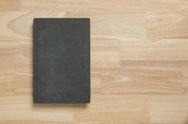 donker oud boek omslag op houten tafel voor mockup blanco sjabloon - Foto, afbeelding