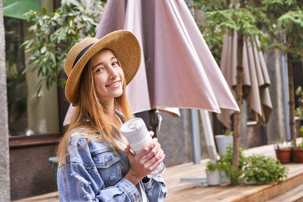 Pretty girl drink beverage outdoors. Buy takeaway coffee in own cup. Real people - Foto, imagen