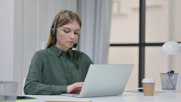 Young Woman with Headset working on Laptop  - Photo, Image