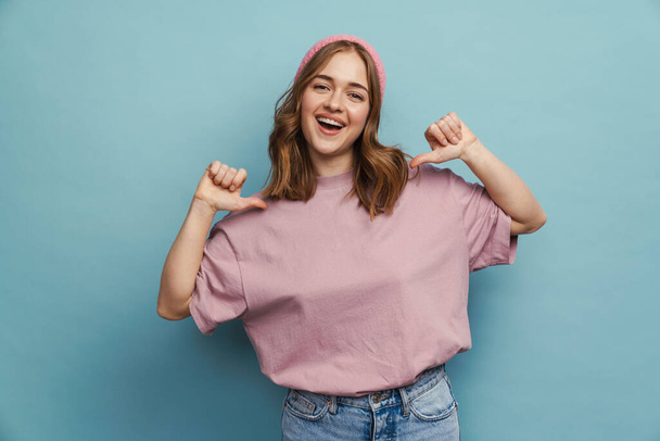 Young happy woman smiling and pointing fingers at herself isolated over blue background - Photo, image
