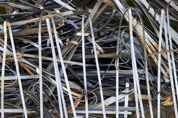 абстрактный фон отходов металлообработки на станке лазерной резки cnc. изогнутые металлические полосы. стальной лом - Фото, изображение