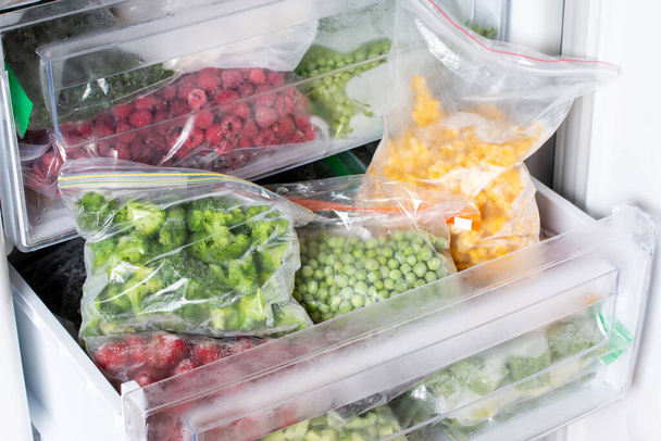Заморожена їжа в морозильній камері. Заморожені овочі, готові страви в морозильній камері. Заморожене м'ясо, продукти харчування та овочі. Зберігання продуктів харчування
 - Фото, зображення