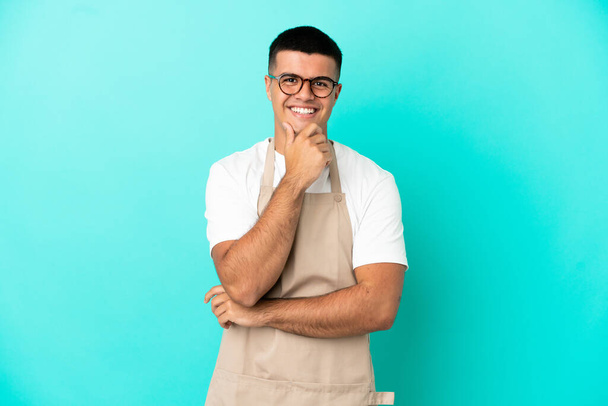 Restaurante garçom homem sobre isolado fundo azul com óculos e sorrindo - Foto, Imagem