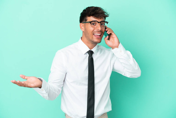 Üzleti kaukázusi férfi elszigetelt kék háttér tartja a beszélgetést a mobiltelefon valakivel - Fotó, kép