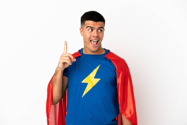 Super Hero over isolated white background intending to realizes the solution while lifting a finger up - Photo, Image