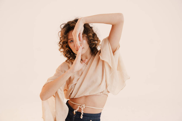 Young hispanic woman with curly hair dancing on camera isolated over white background - Foto, Imagem
