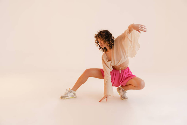 Young hispanic woman wearing skirt dancing on camera isolated over white background - Foto, immagini