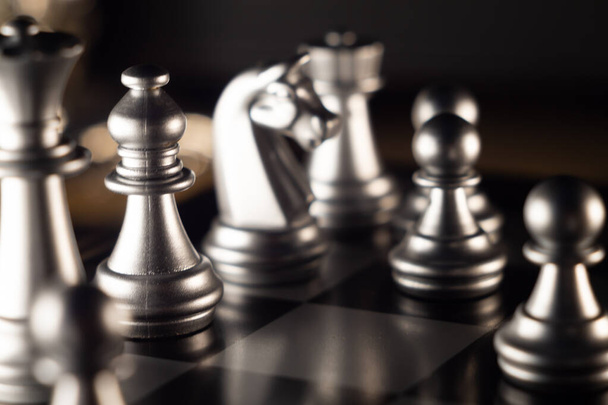 A closeup shot of a chessboard with pieces on a dark background - Photo, image