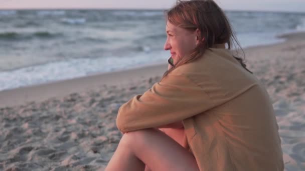 Une femme parle au téléphone sur la plage près de l'océan - Séquence, vidéo