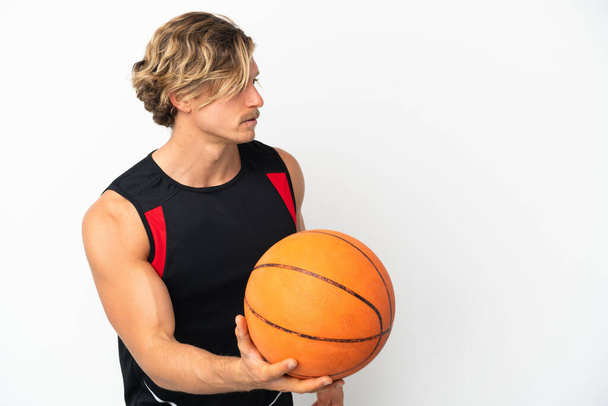 Mladý blondýnka muž izolovaný na bílém pozadí hrát basketbal - Fotografie, Obrázek