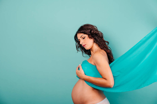 Mujer embarazada esperando un niño acaricia su vientre - Foto, Imagen