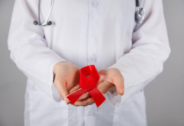 Woman doctor holding an AIDS red ribbon. - Valokuva, kuva