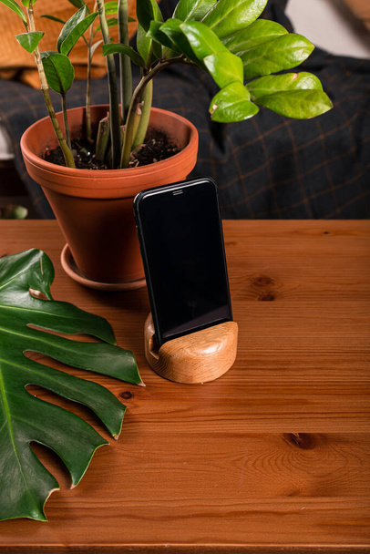 Black smartphone with blank screen standing on wooden table, for application technology mockup and text image space. - Fotó, kép