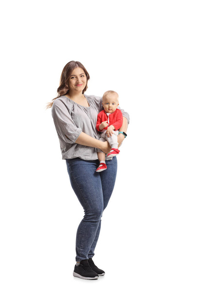 Full length portrait of a mother holding her baby isolated on white background - 写真・画像