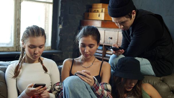 Gruppe unterschiedlicher Schüler steckt in Mobiltelefonen fest, die online chatten  - Foto, Bild