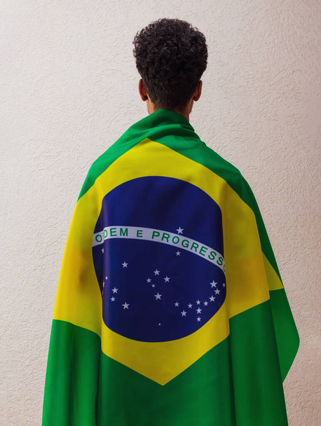 Back of a man with Brazilian flag hero cape isolated on white. - Zdjęcie, obraz
