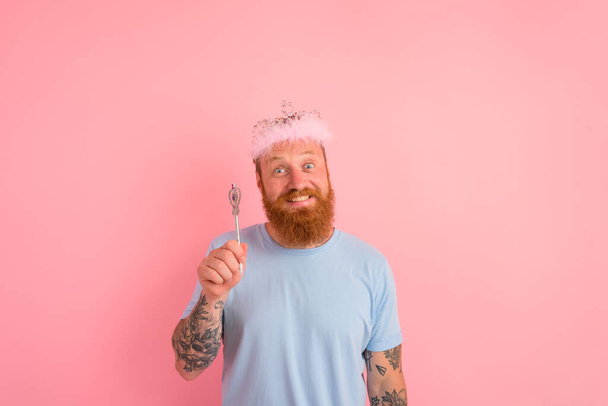 Gelukkige man met baard en tatoeages gedraagt zich als een prinses van een verhaal - Foto, afbeelding