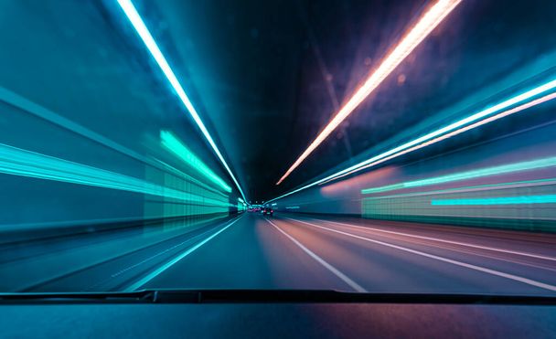 Водители переднего вида, быстро едущие по туннелю на автомобиле с большим количеством нечетких огней. - Фото, изображение