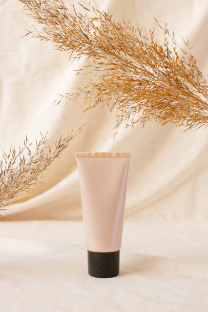 Maquillage tonale CC ou BB crème fond de teint maquillage tube modèle sur draperie de lin et plante sèche. Concept eco cosmétique bio à l'extrait naturel. Maquette - Photo, image