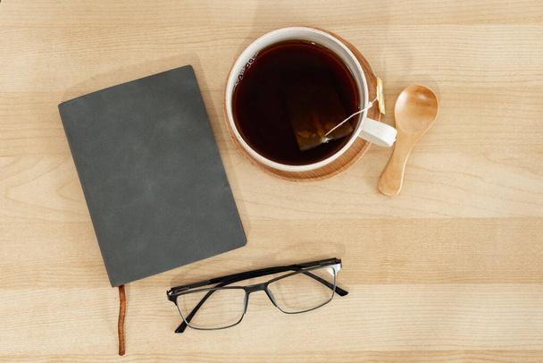 Una vista dall'alto di occhiali per notebook e una tazza sulla scrivania - Foto, immagini