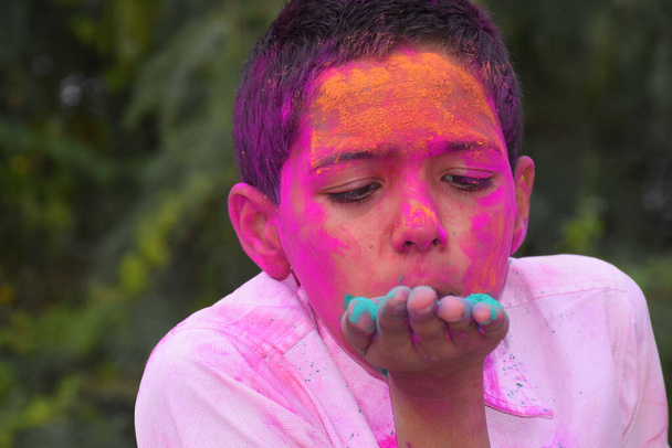 Poika leikkii väreillä iloisella tuulella. Konsepti Intian festivaali Holi - Valokuva, kuva