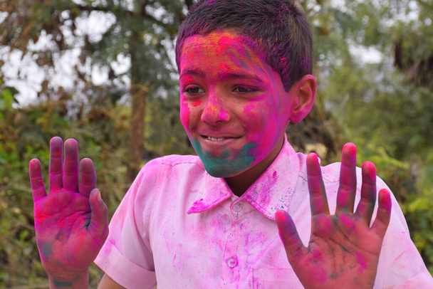 Το αγόρι παίζει με τα χρώματα, έχει χαρούμενη διάθεση. Concept για ινδικό φεστιβάλ Holi - Φωτογραφία, εικόνα