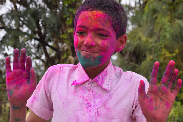 Chłopak bawiący się kolorami, w radosnym nastroju. Koncepcja indyjskiego festiwalu Holi - Zdjęcie, obraz