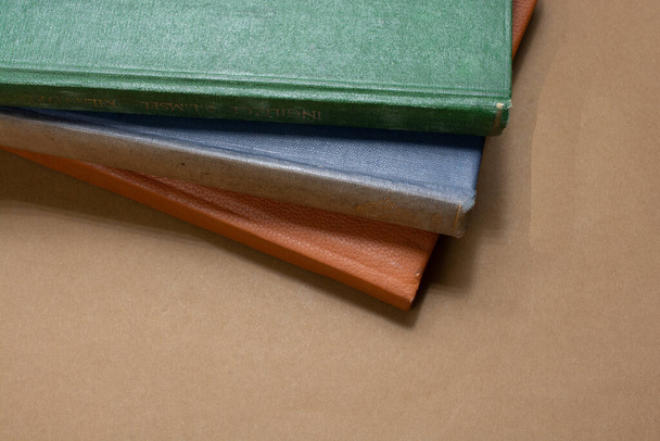 A closeup shot of colorful old journals on a table - Fotó, kép