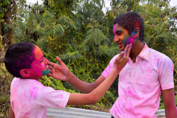 два мальчика играют в цветах в счастливой позе, концепция для индийского фестиваля Холи - Фото, изображение