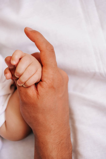 Closeup of father holding baby hand fathers day - Фото, изображение