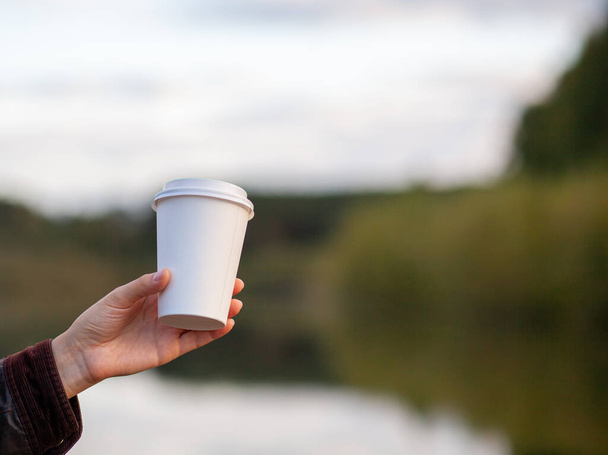 White paper cup with coffee in woman hand. Time for drink coffee in city. Coffee to go. Enjoy moment, take a break. Disposable paper cup closeup. Delicious hot beverage. Blank space for text, mockup - Photo, Image