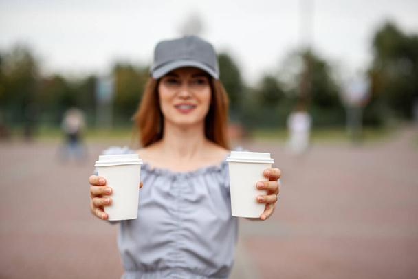 Two white paper cup with coffee in woman hand. Time for drink coffee in city. Coffee to go. Enjoy moment, take a break. Disposable paper cup closeup. Delicious hot beverage. Blank space for text, - Zdjęcie, obraz