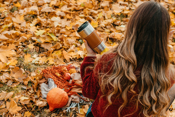 Zero Waste Fall Activities, Things to Do for Fall Season, Environmental friendly, eco living. Enjoying autumn season. Young beautiful woman with reusable coffee cup resting in fall autumn park. - Foto, imagen