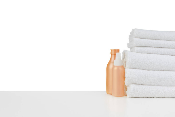 Composition of cosmetic bottles and towels isolated on white - Фото, изображение