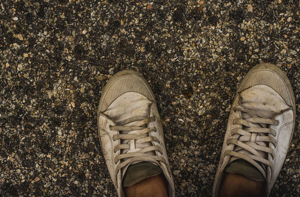 people wearing the old and dirty sneakers on road - Foto, imagen