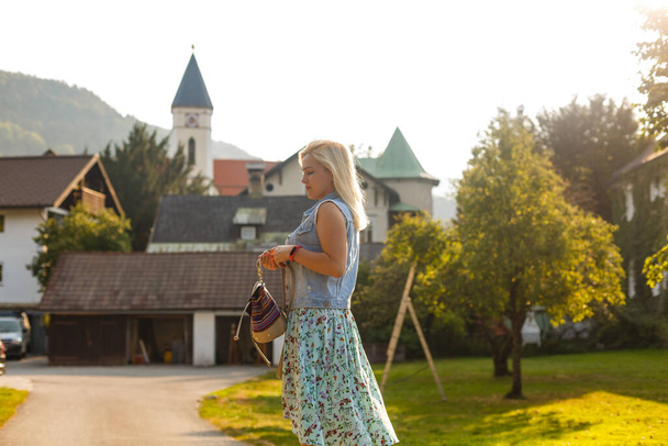 Νεαρή γυναίκα στέκεται δίπλα σε ξύλινα σπίτια. χωριό στα βουνά. Ταξίδι, Lifestyle Concept. Αλπεις, Ευρώπη. - Φωτογραφία, εικόνα