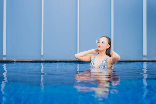 Портрет красивая молодая азиатская женщина расслабиться улыбка вокруг открытый бассейн для отдыха - Фото, изображение