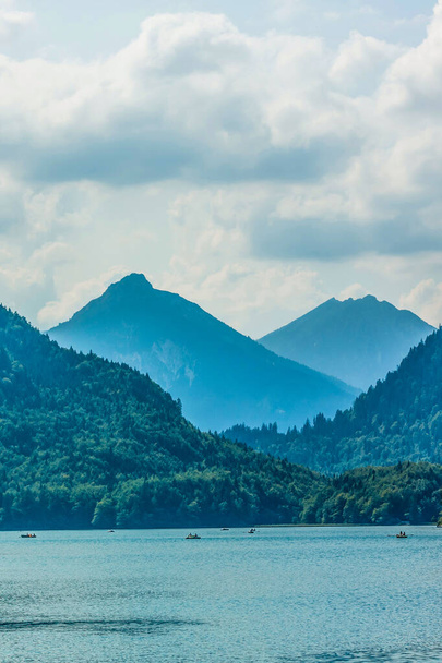 Neuschwanstein yakınlarındaki bir dağ gölünde dinlen. Aile teknede oturuyor. - Fotoğraf, Görsel