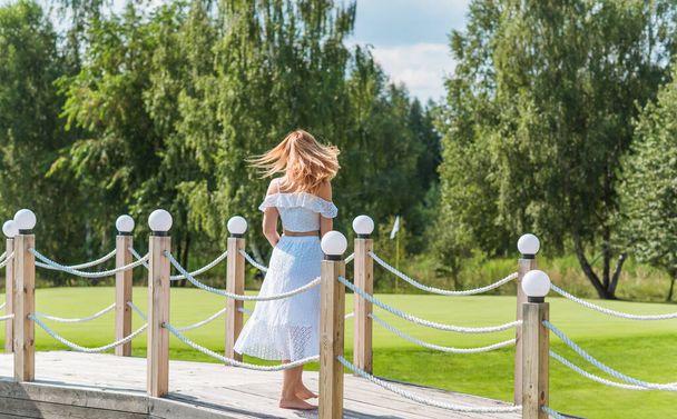 Lady in white cotton suit, crop top and skirt at nature, vacation scene - Photo, Image